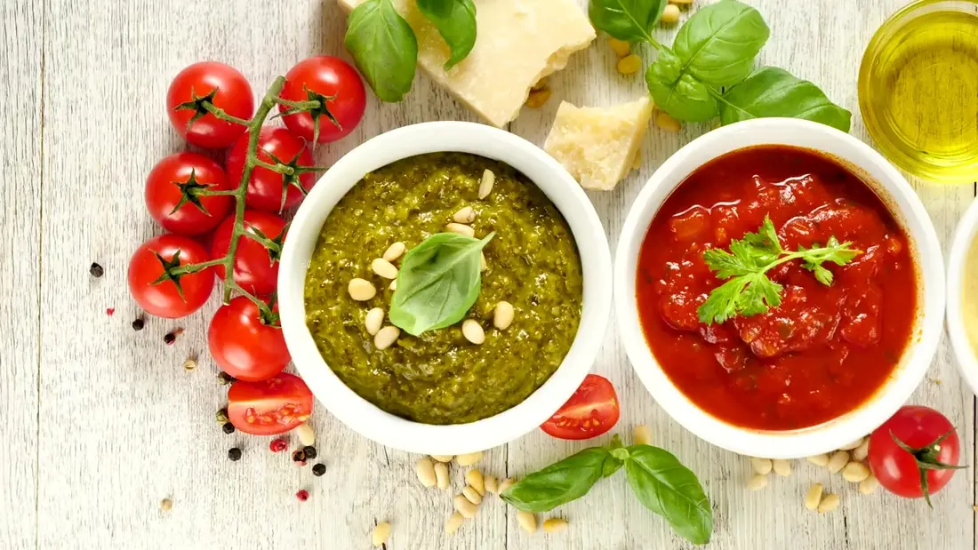 Green and red dips in bowls with tomatoes