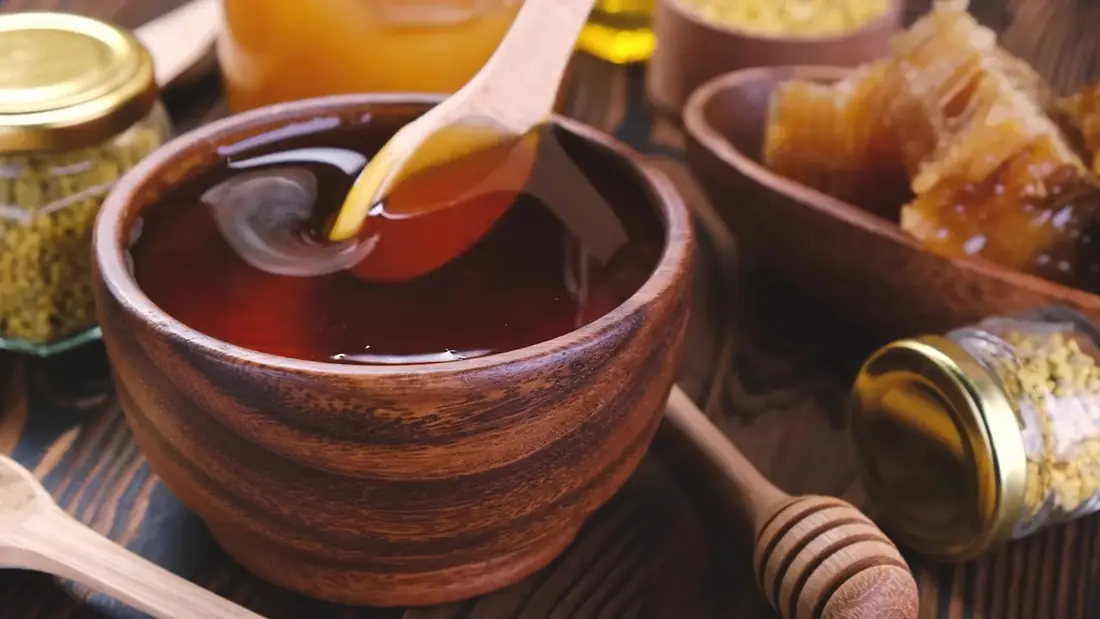 Honey drizzled from a wooden spoon